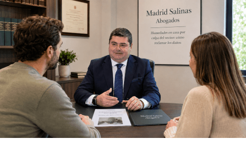 Abogado civil de Madrid Salinas Abogados asesorando a clientes en un despacho sobre una reclamación por humedades y filtraciones causadas por un vecino.