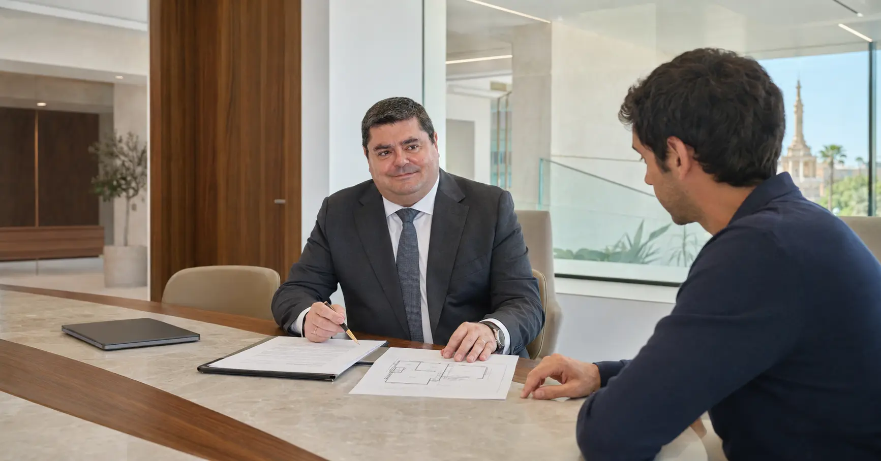 Juan Madrid Salinas, abogado civil en Sevilla, revisando un contrato con un cliente