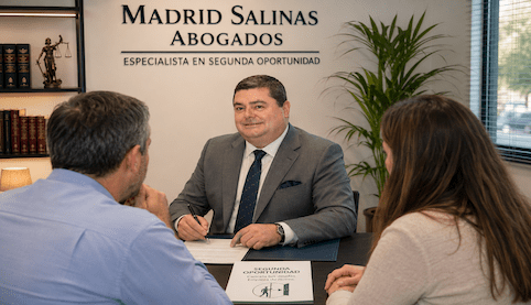 Abogado asesorando a dos clientes sobre los requisitos de la Ley de la Segunda Oportunidad